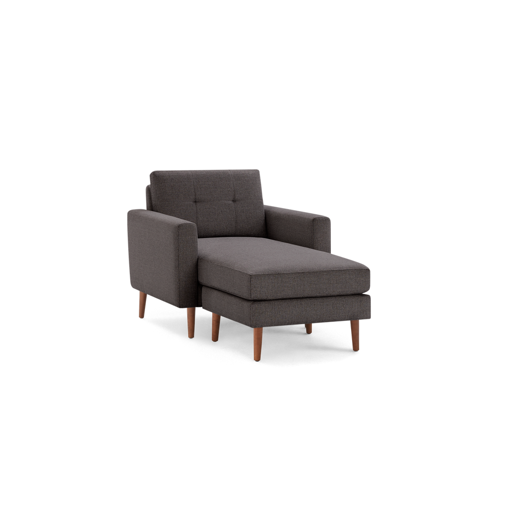 Dark gray fabric chaise lounge chair with wooden legs, tufted backrest, and armrests.