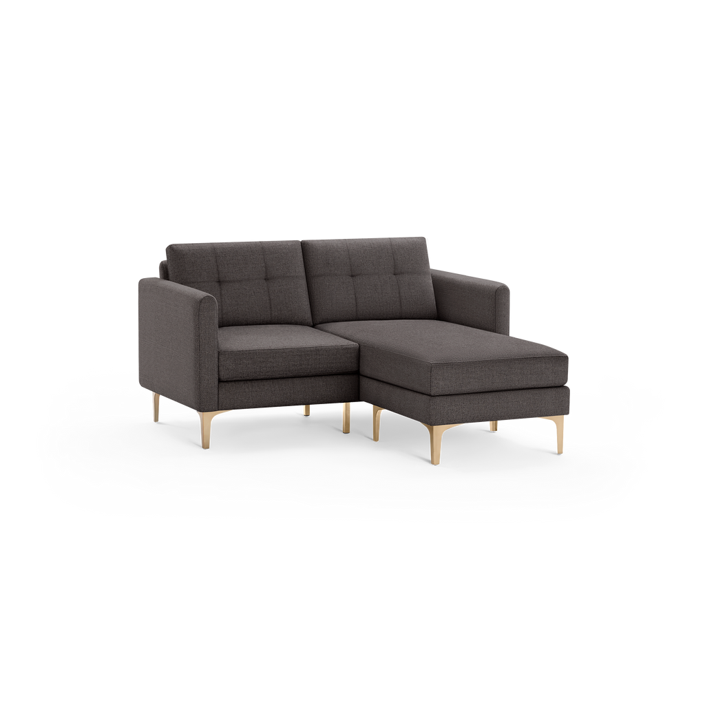 Modern small sectional sofa with dark gray fabric upholstery and gold metal legs, featuring tufted back cushions and a chaise lounge on the right side.
