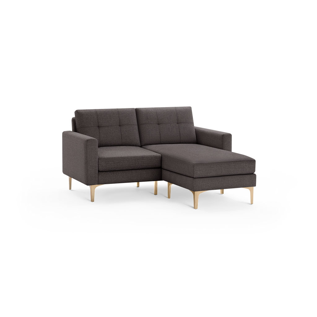 Modern dark gray fabric sectional sofa with tufted cushions and light wooden tapered legs, featuring a chaise lounge on the right side.