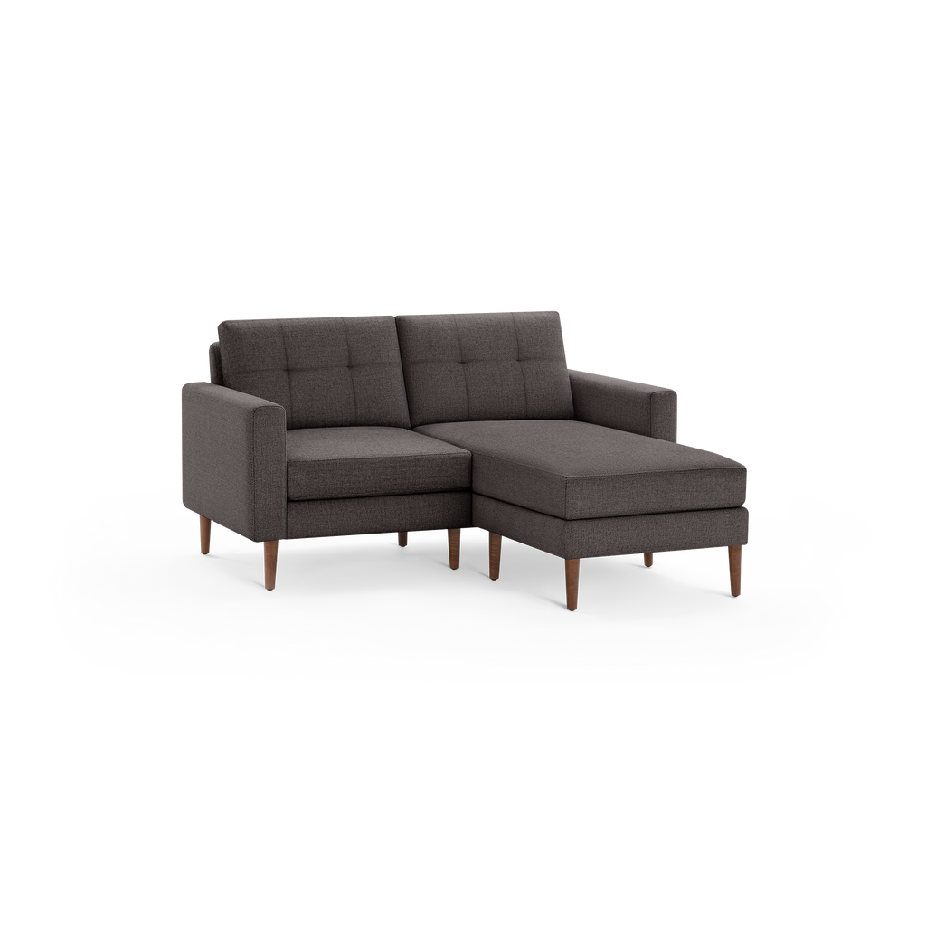 Dark gray modern sectional sofa with tufted back cushions, straight arms, wooden legs, and chaise lounge on the right side.