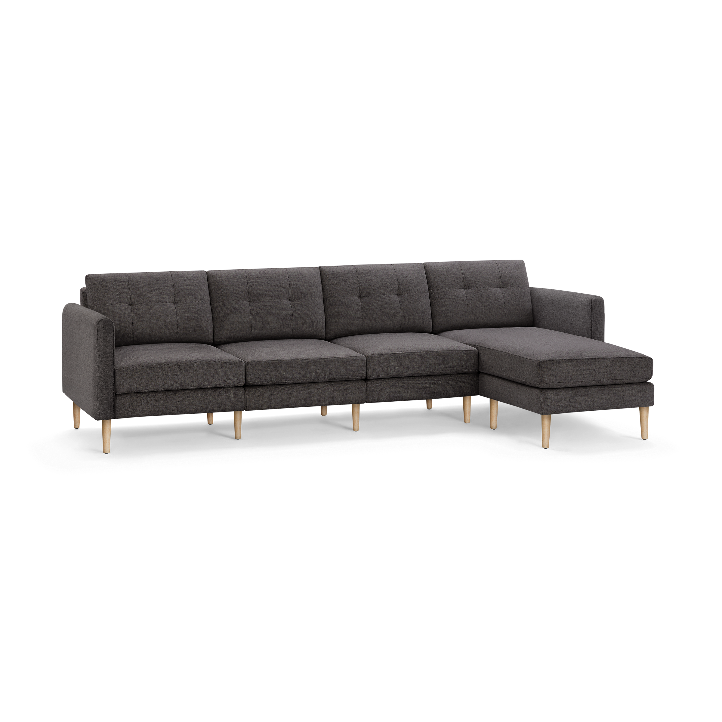 Dark gray fabric sectional sofa with tufted back cushions and light wooden legs, featuring a chaise lounge on the right side.