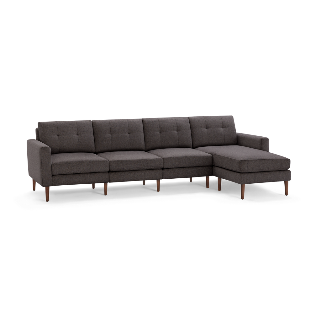 Modern dark gray fabric sectional sofa with tufted back cushions and wooden legs, featuring a chaise on the right side.