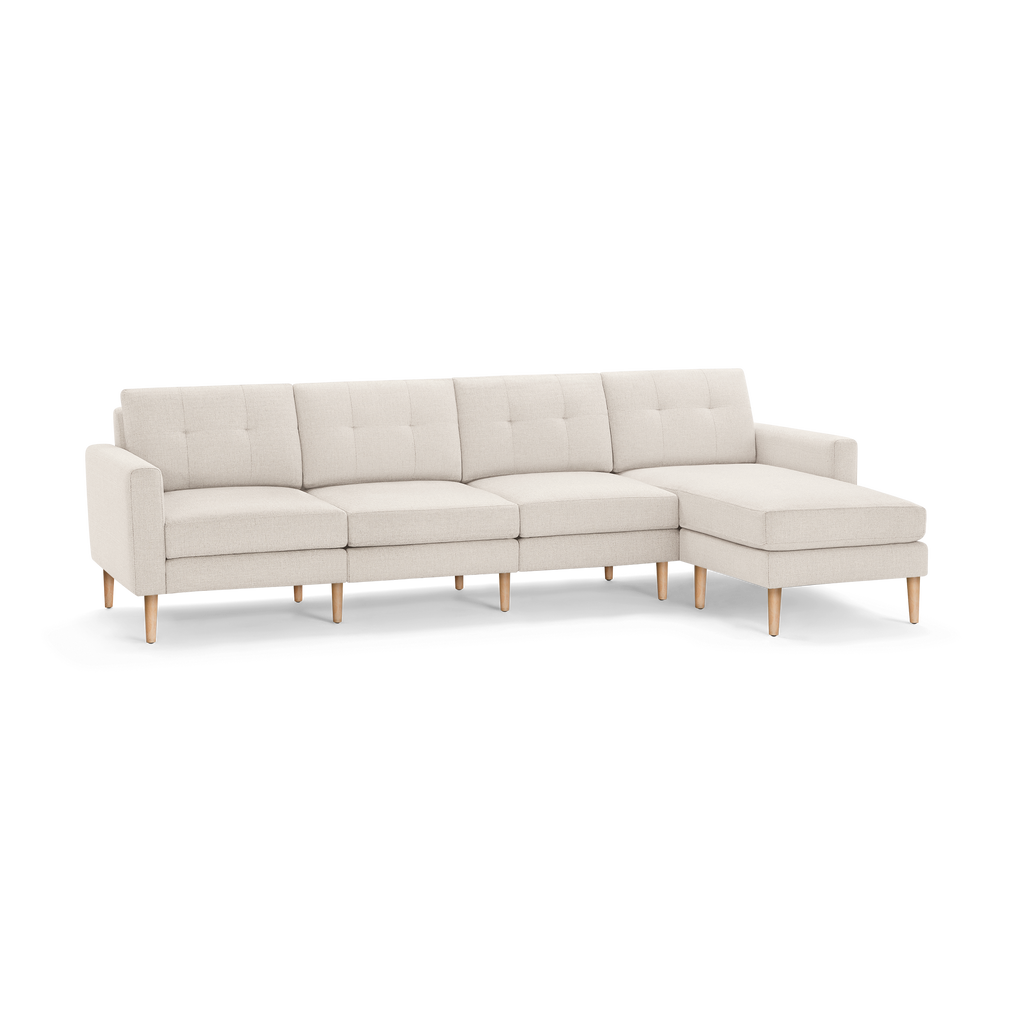 Light beige modern sectional sofa with tufted back cushions, wooden legs, and a right-side chaise lounge.
