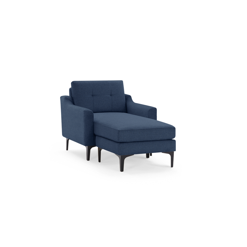 Modern navy blue upholstered chaise lounge with tufted backrest, sleek armrests, and black tapered metal legs.