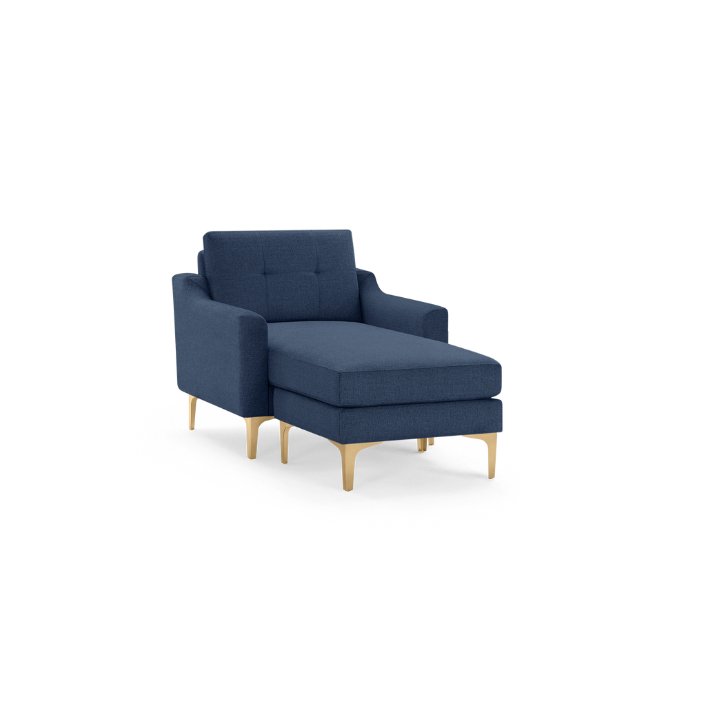 Blue upholstered chaise lounge chair with tufted backrest and slim gold metal legs, modern and minimalist design.