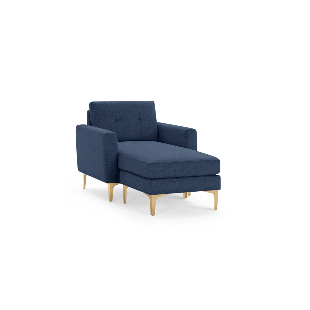 Modern navy blue chaise lounge chair with tufted backrest and sleek gold legs isolated on black background.