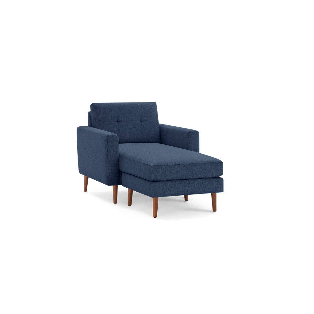 Blue upholstered chaise lounge chair with tufted backrest, wooden legs, and cushioned seat, designed for modern living spaces.