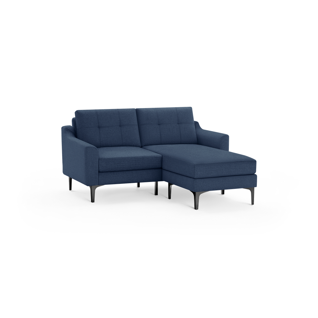 Dark blue fabric sectional sofa with tufted back cushions, chaise lounge on right side, and black metal legs.