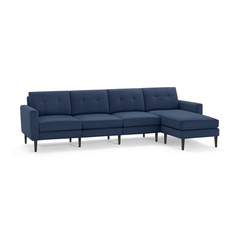 Modern navy blue fabric sectional sofa with tufted back cushions and black tapered legs, featuring a chaise lounge on the right side.