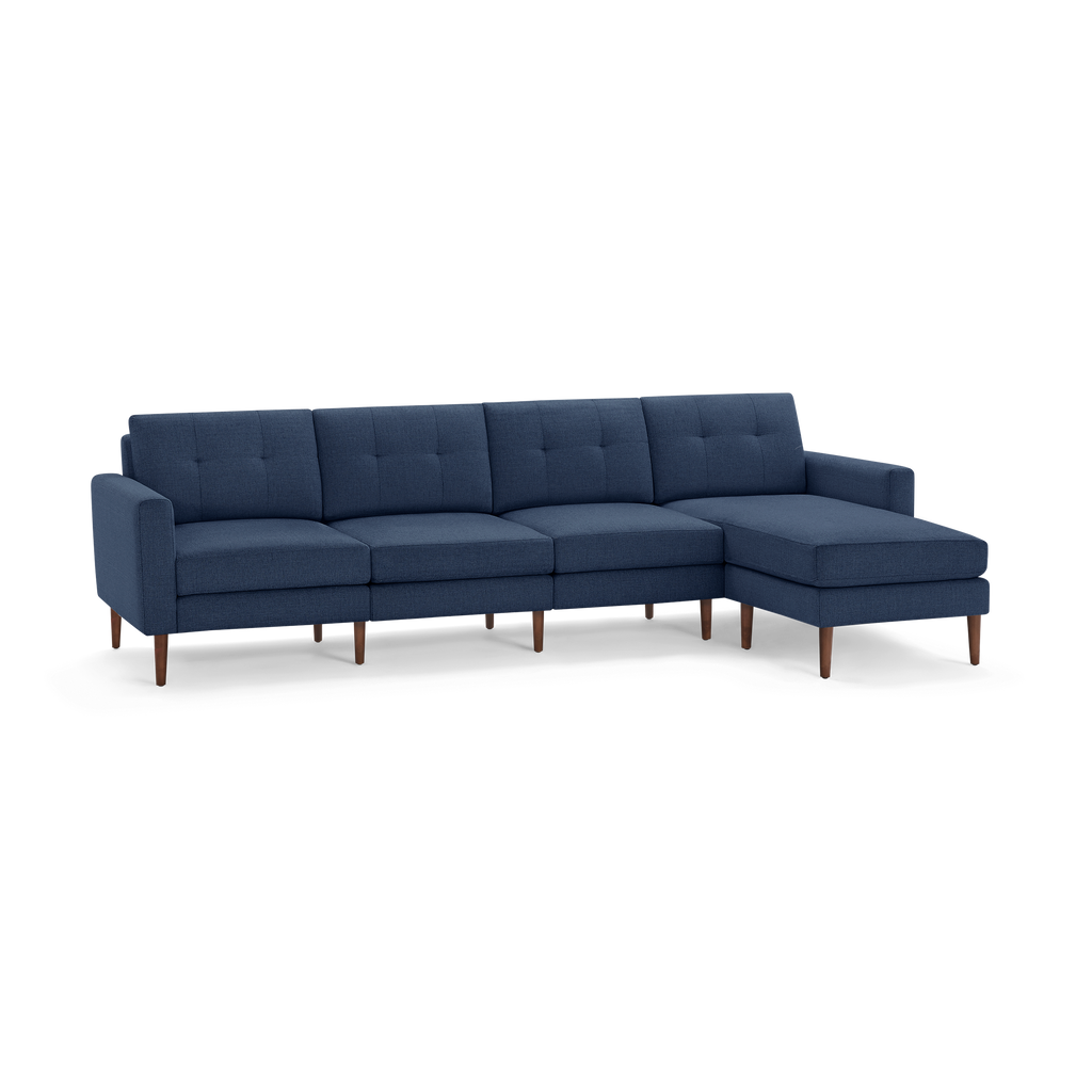 Modern navy blue sectional sofa with tufted cushions, wooden legs, and right-side chaise lounge for spacious seating.