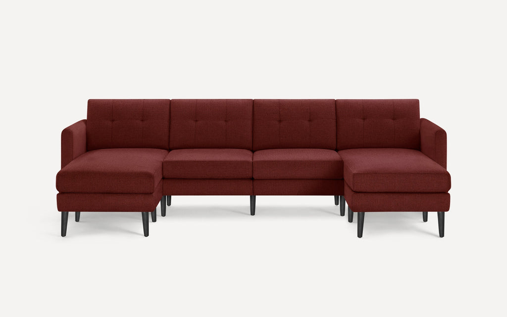 Modern sectional sofa in deep burgundy fabric with tufted back cushions, black tapered legs, and two chaise ends.