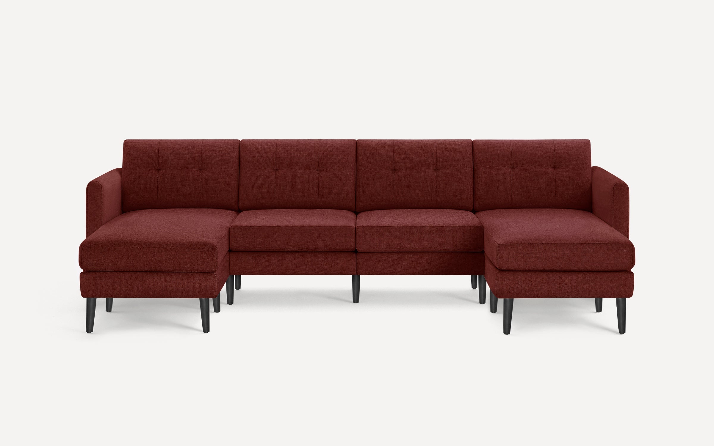 Modern sectional sofa in deep burgundy fabric with tufted back cushions, black tapered legs, and two chaise ends.