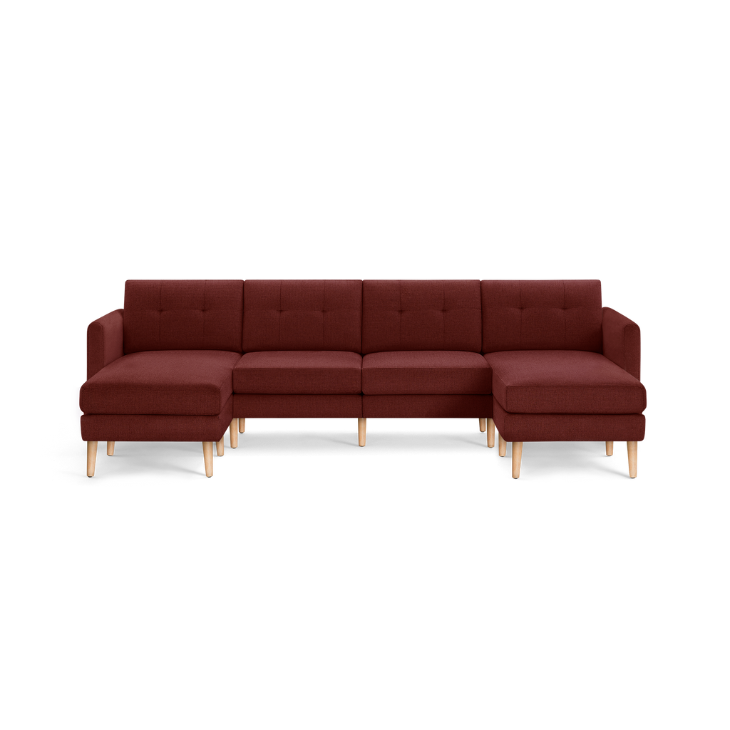 Modern U-shaped sectional sofa in dark red fabric with tufted back cushions and light wooden legs.