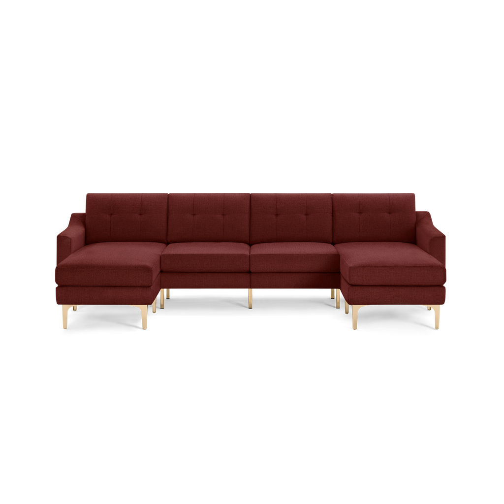 Large modern L-shaped sectional sofa upholstered in deep red fabric with gold metal legs and tufted back cushions.