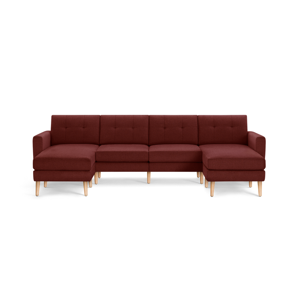 Large L-shaped sectional sofa with deep red fabric upholstery, tufted backrests, wooden legs, and armrests on each end.