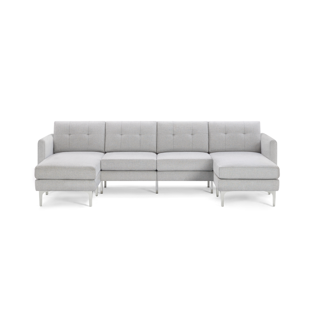 Light gray modern sectional sofa with tufted back cushions, metal legs, and chaise lounges on both ends, isolated on black background.