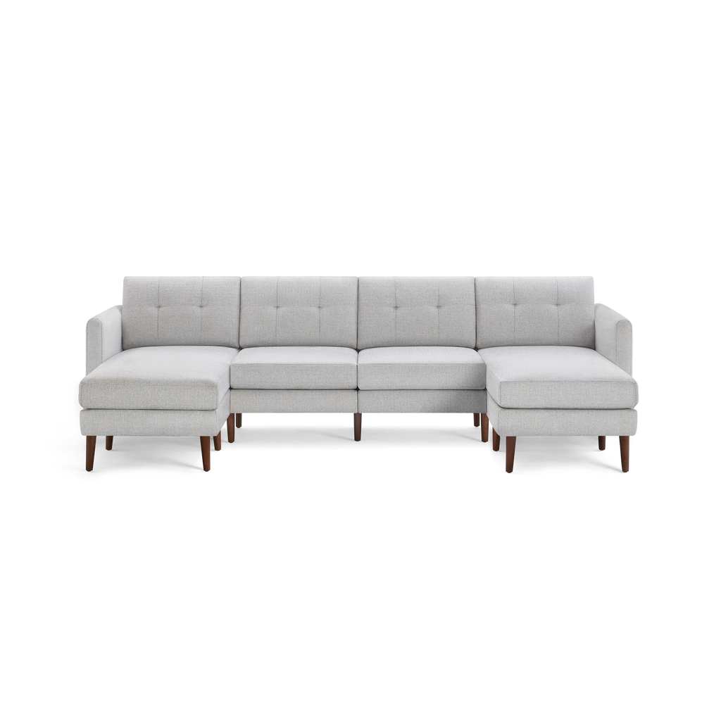 Light gray fabric sectional sofa with tufted back cushions, wooden legs, and chaise lounge on both ends.