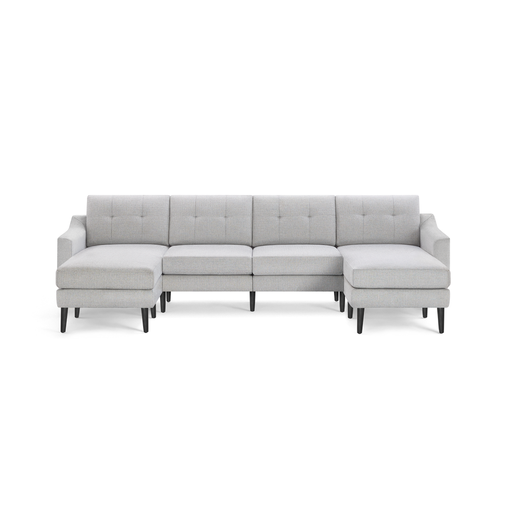 Light gray, modern sectional sofa with tufted back cushions, two chaise lounges on either side, and black tapered legs.