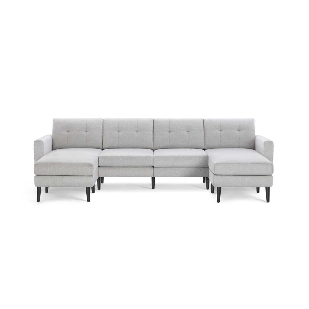 Modern sectional sofa in light gray fabric with tufted back cushions, black tapered legs, and symmetrical chaise ends.