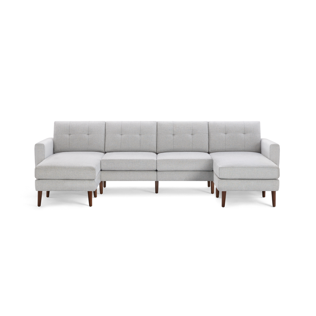 Light gray fabric sectional sofa with tufted back cushions, wooden legs, and chaise lounges on both ends.
