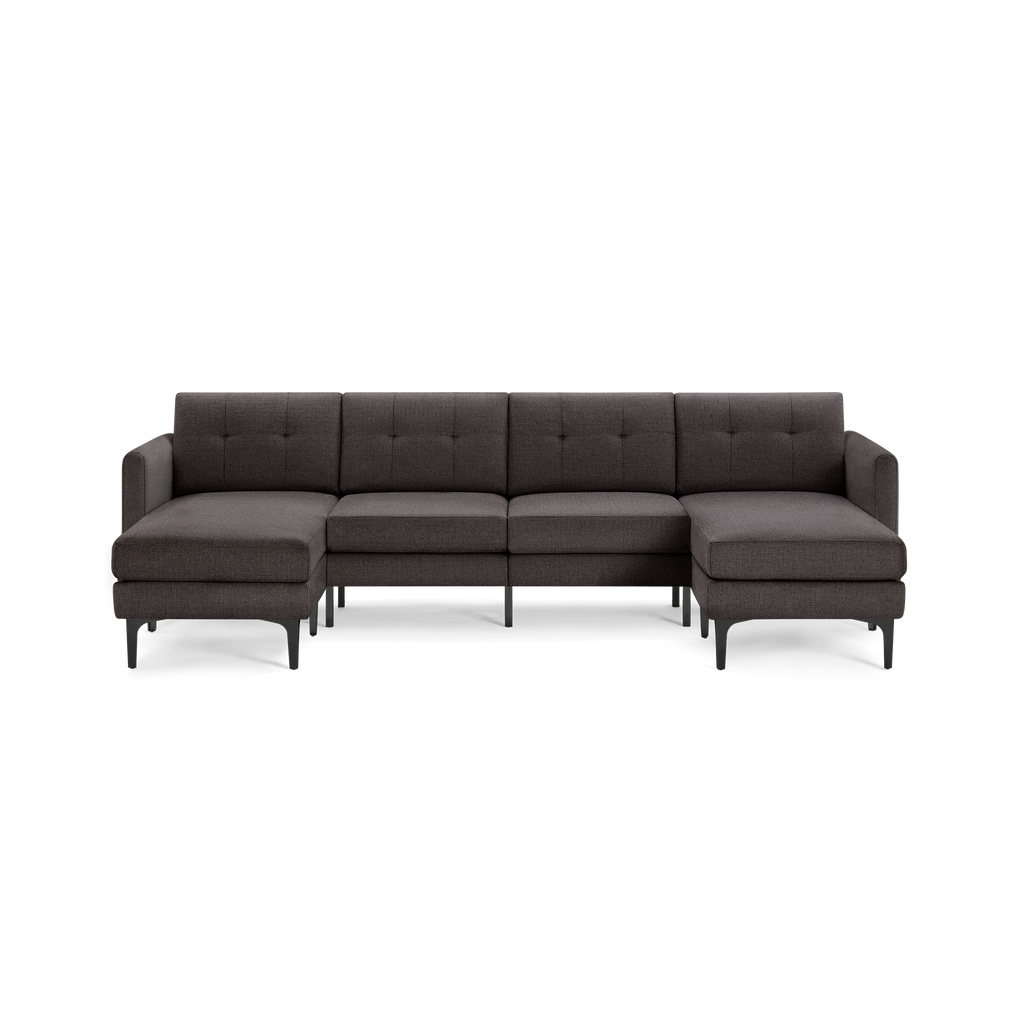 Large modern sectional sofa with dark gray tufted fabric upholstery, chaise lounges on both ends, and sleek black legs.