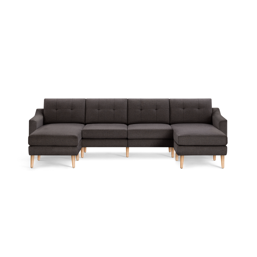 Dark gray mid-century modern sectional sofa with button-tufted back cushions and light wooden legs.