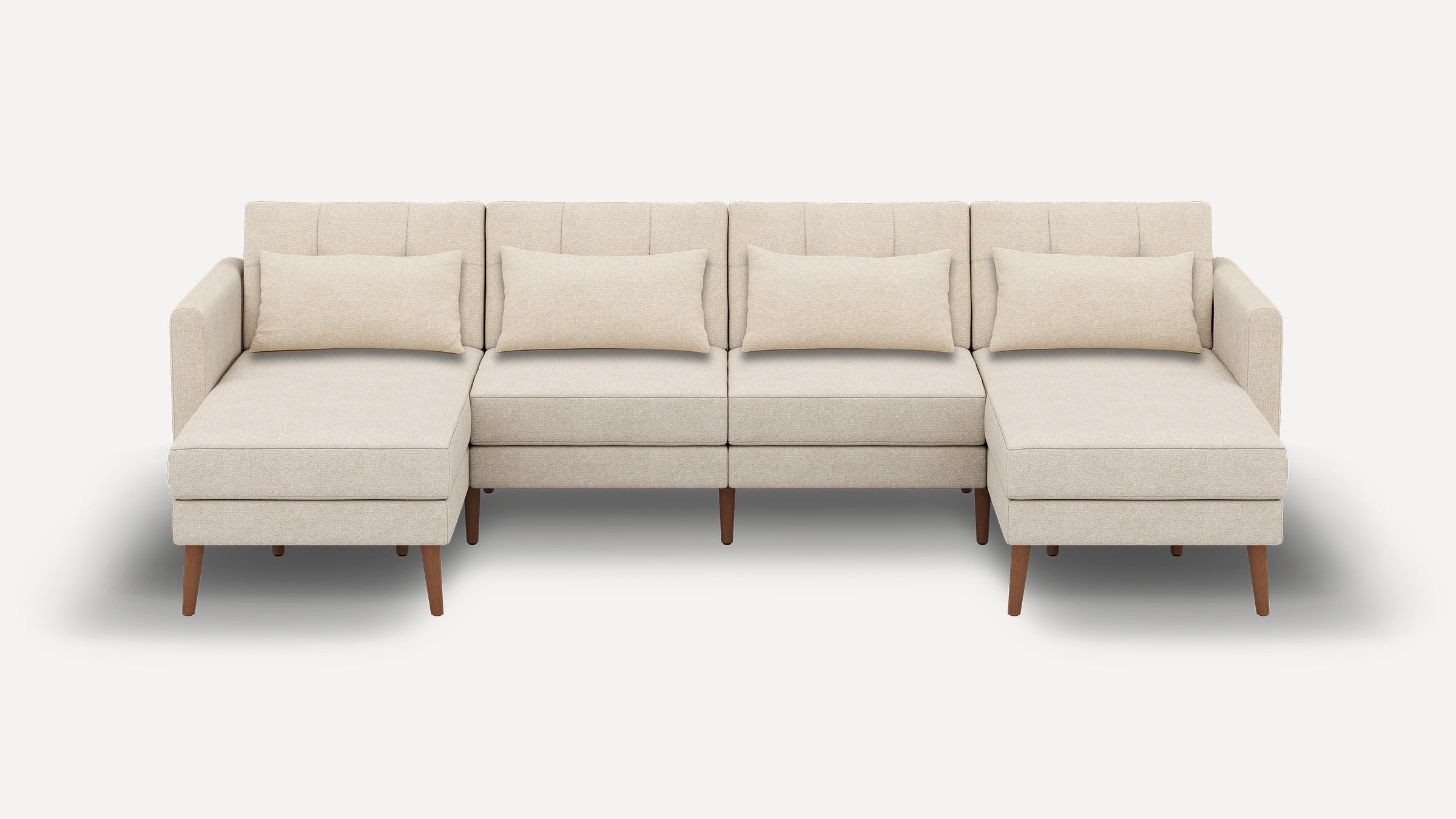 Beige sectional sofa with chaise lounges on both ends, four back cushions, wooden legs, and minimalist design.