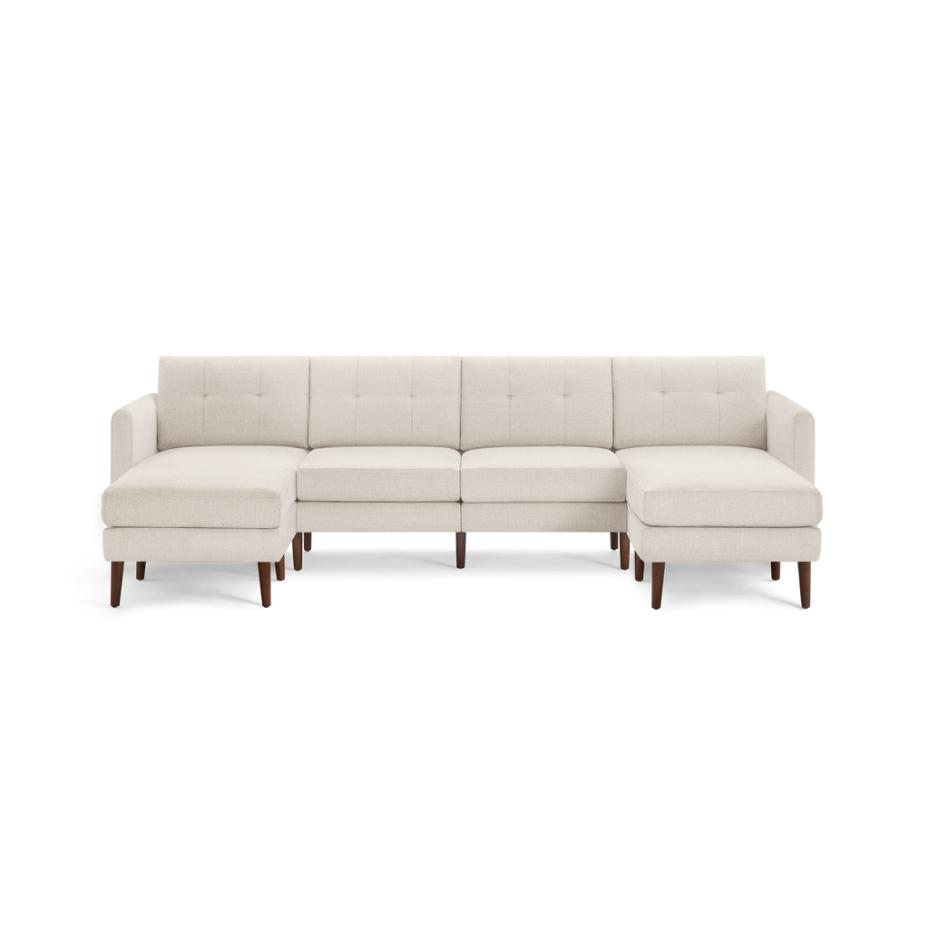 Cream-colored modern sectional sofa with tufted back cushions, wooden legs, and chaise lounges on both ends.