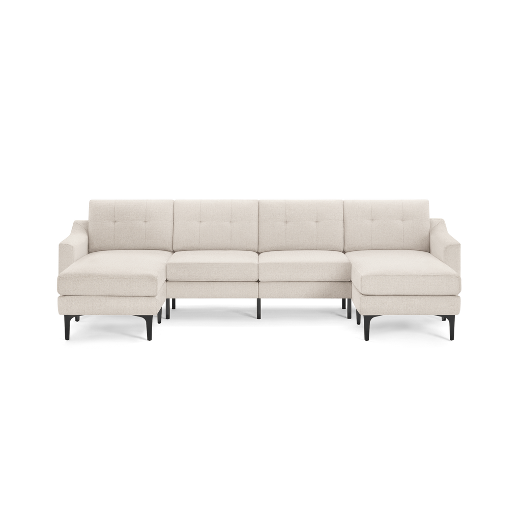 Beige fabric sectional sofa with tufted back cushions, black legs, and symmetrical chaise lounges on both ends.