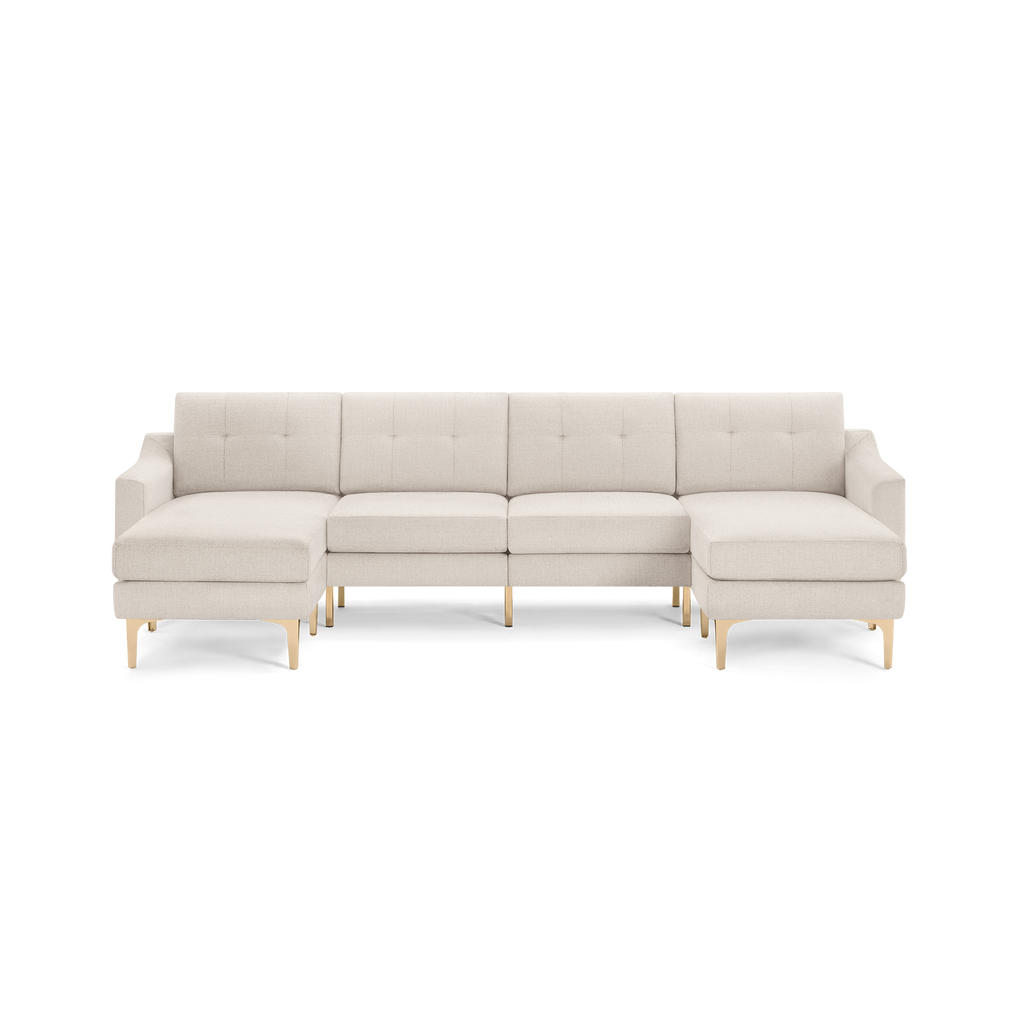 Cream-colored L-shaped sectional sofa with tufted back cushions and light wooden legs, featuring a left chaise lounge.