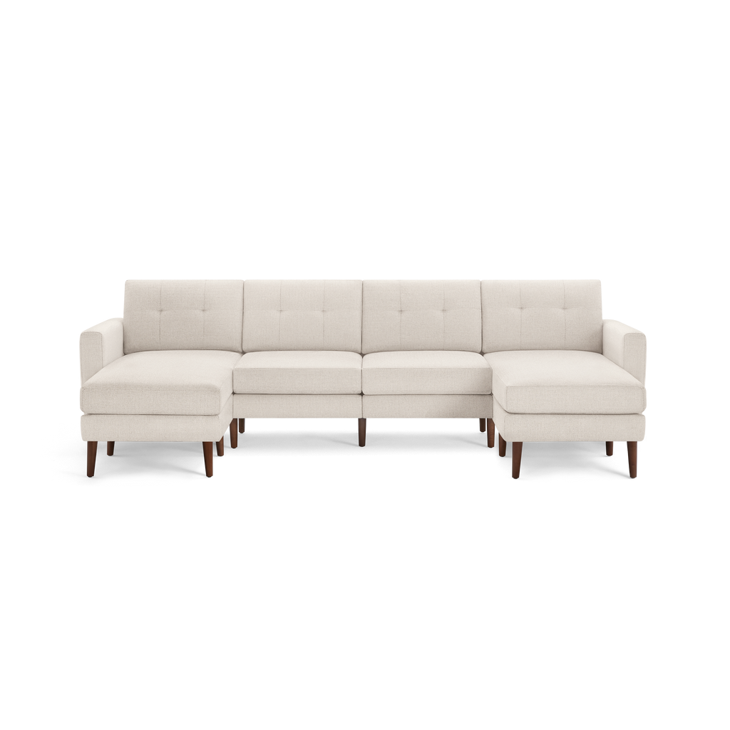 Cream-colored sectional sofa with tufted back cushions, wooden legs, and chaise seats on both ends.