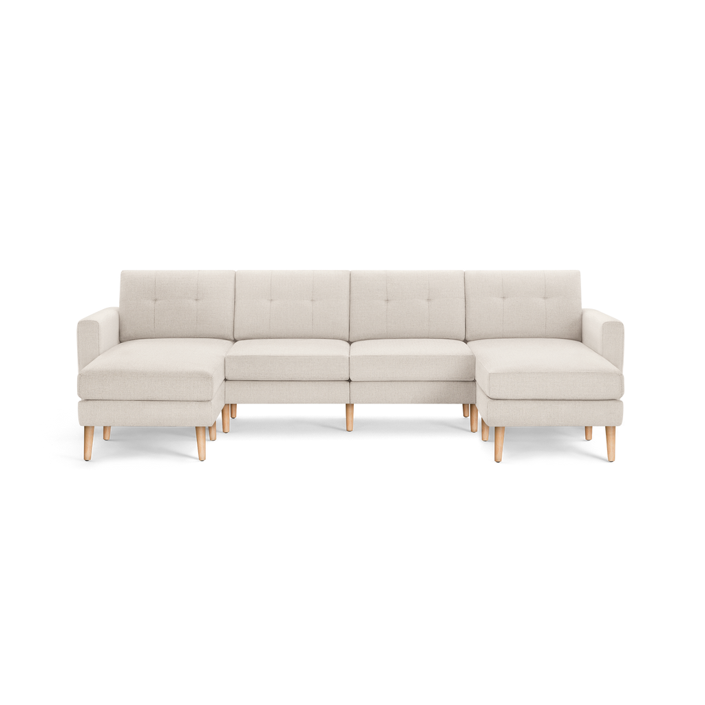 Modern beige sectional sofa with tufted back cushions, wooden legs, and two chaise lounges on either end.