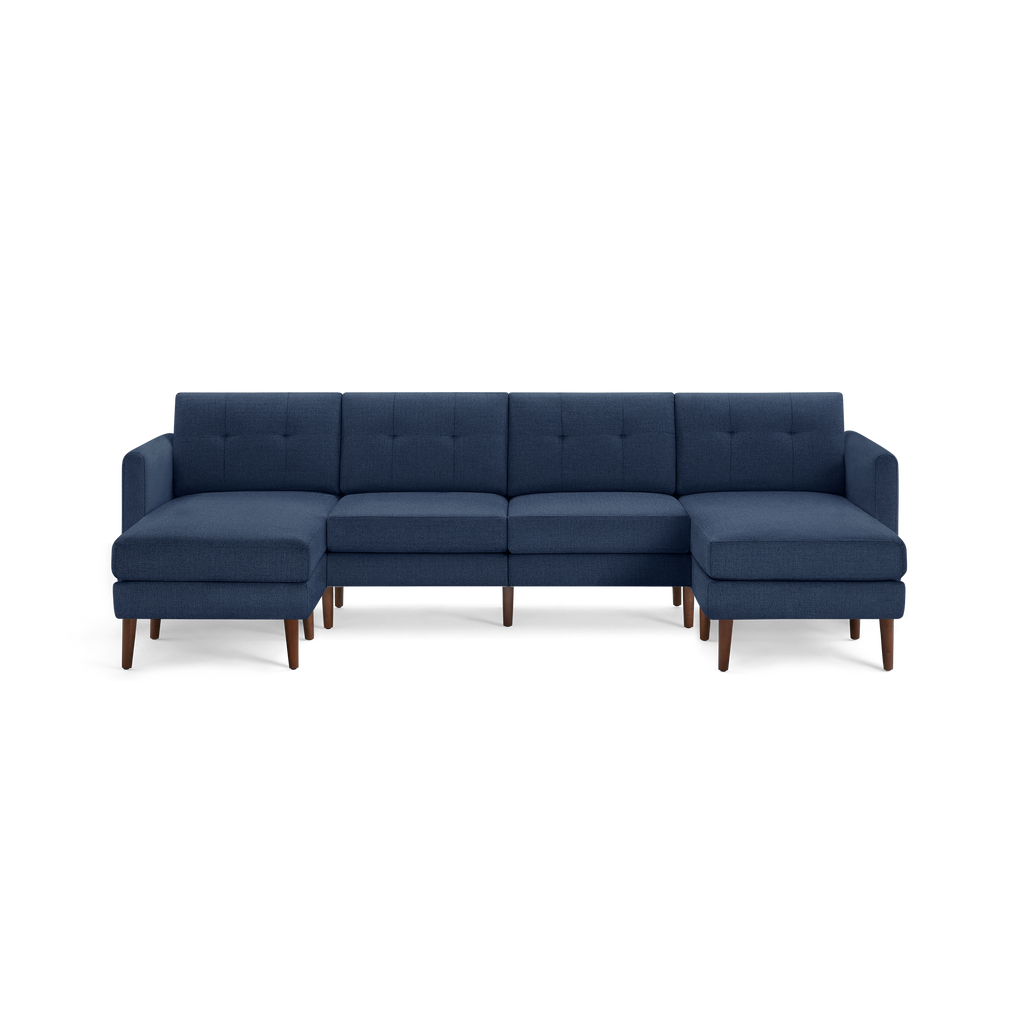 Modern navy blue fabric sectional sofa with tufted back cushions and wooden legs, featuring chaise lounges on both ends.
