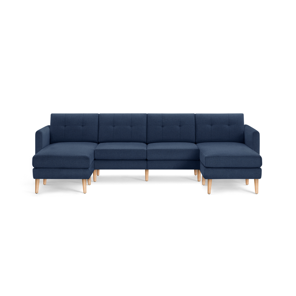 Large modern navy blue sectional sofa with tufted back cushions and light wooden legs, featuring left and right chaise lounges.