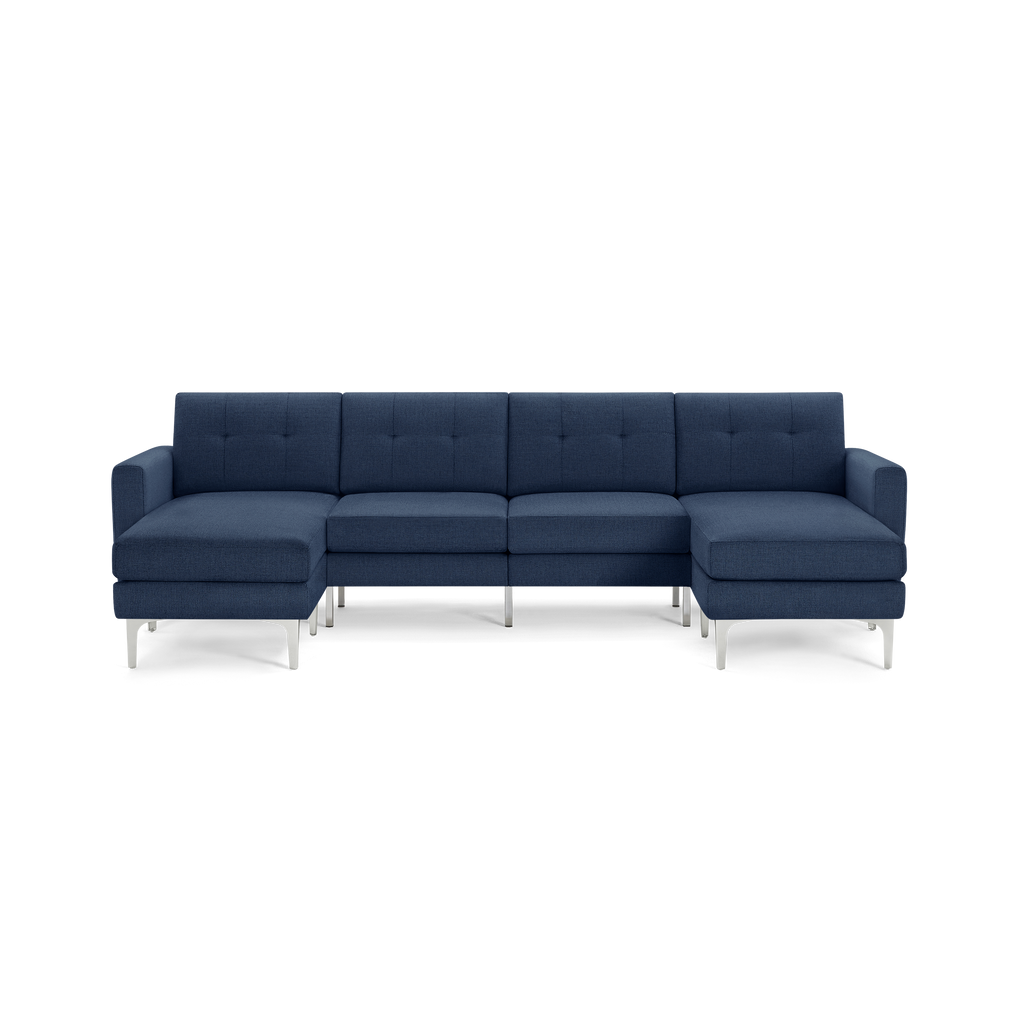 Modern U-shaped sectional sofa in dark blue fabric with tufted back cushions and sleek silver metal legs.