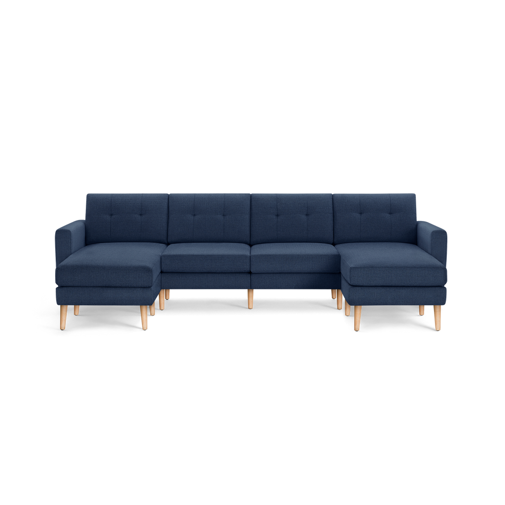 Large modern navy blue fabric sectional sofa with tufted cushions and light wooden legs, featuring left and right chaise lounge ends.