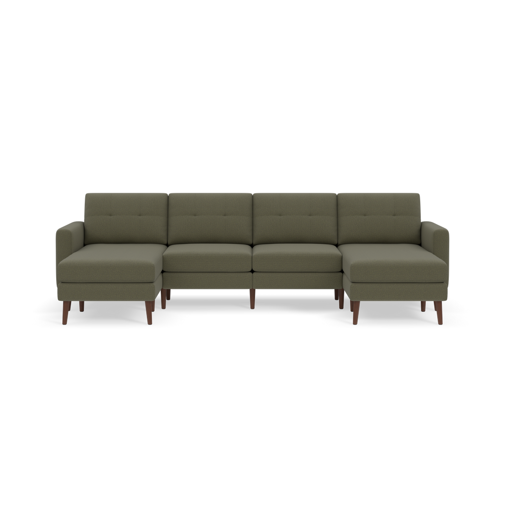 Green sectional sofa with tufted backrests, wooden legs, and chaise lounges on both ends against a black background.