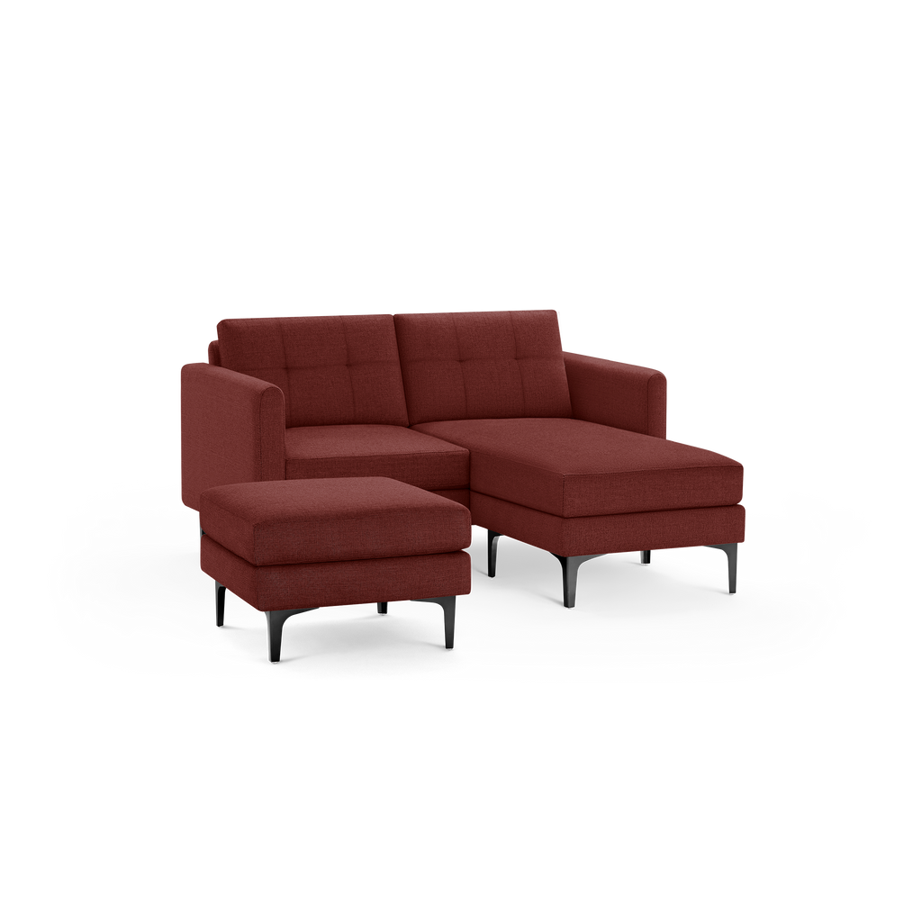 Modern sectional sofa with deep red fabric upholstery, tufted backrests, matching ottoman, and black metal legs.