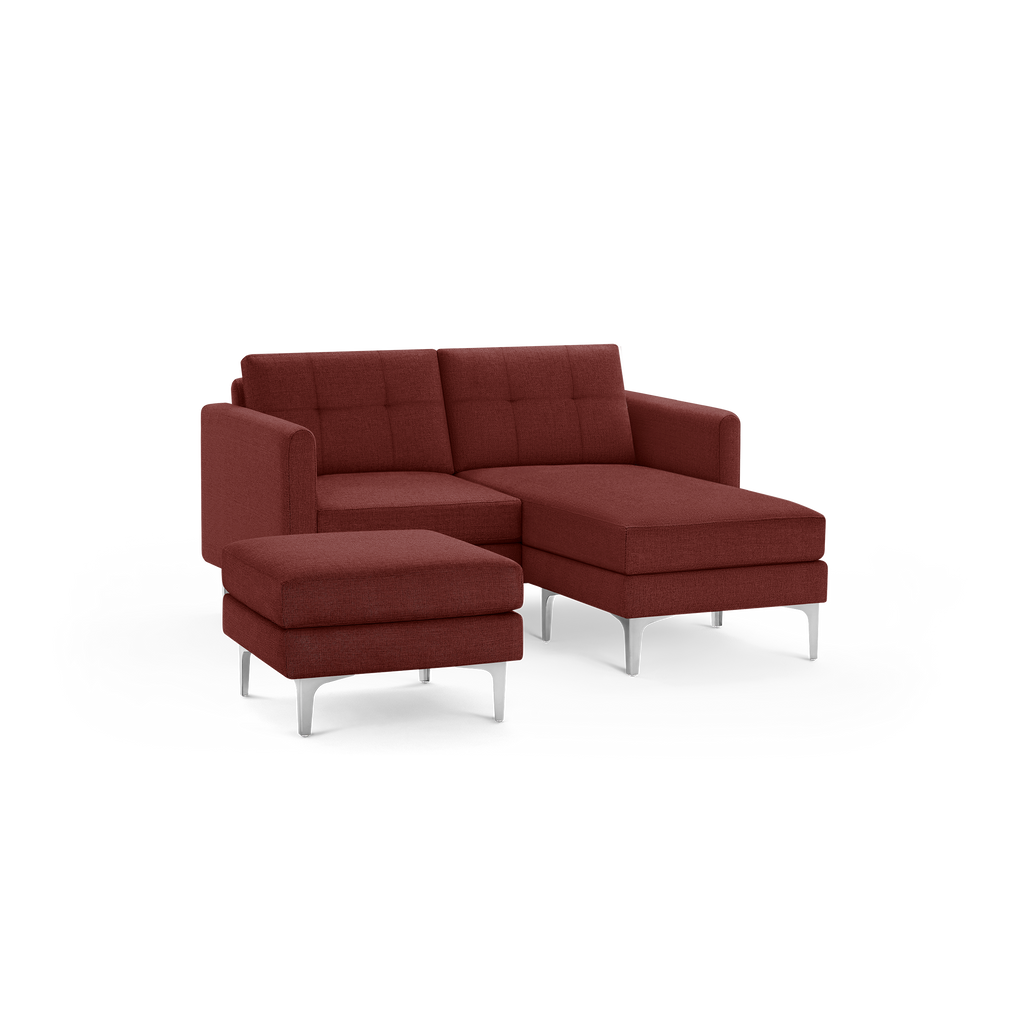 Modern dark red upholstered sectional sofa with tufted back cushions and separate matching ottoman, supported by slim silver metal legs.