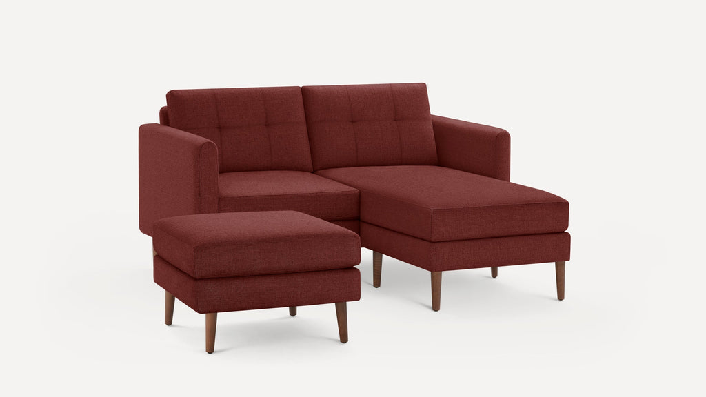Modern sectional sofa with chaise lounge and matching ottoman in deep reddish-brown fabric with wooden legs on white background.