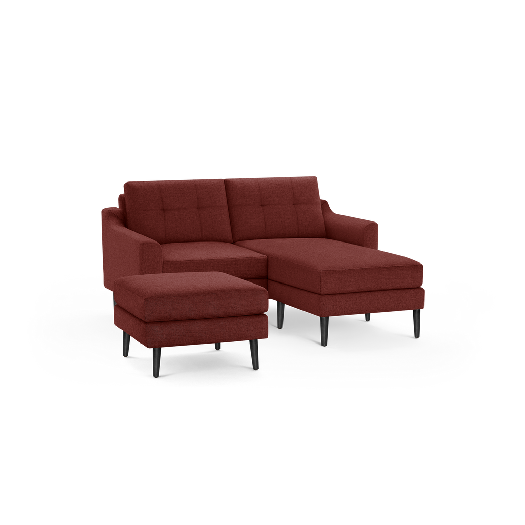 Modern sectional sofa set in deep red fabric with tufted back cushions, black tapered legs, and a matching ottoman.