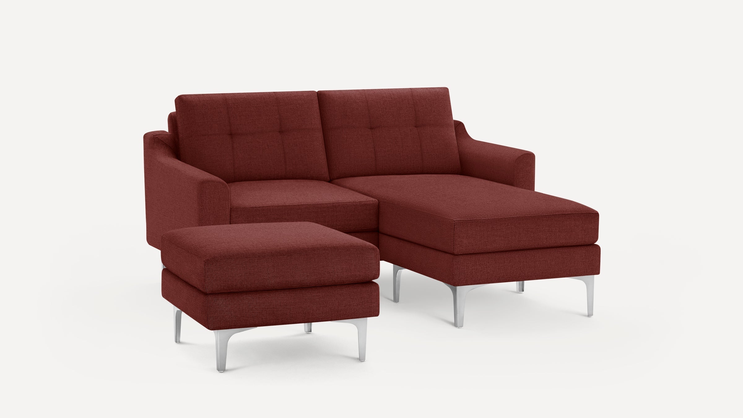 Modern red fabric sectional sofa with tufted back cushions and matching ottoman on metal legs against white background.