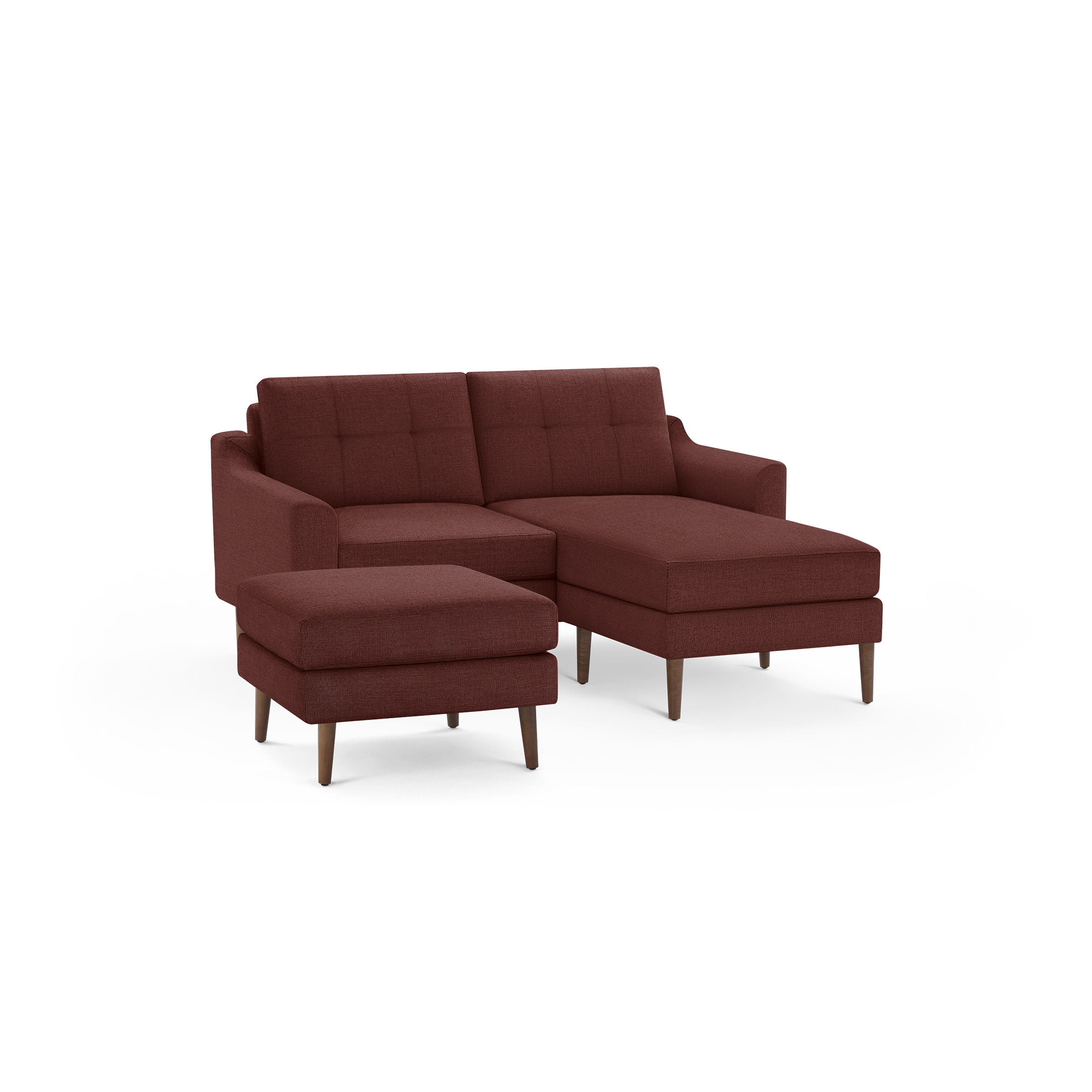 Rust-colored modern sectional sofa with tufted back cushions, matching ottoman, and wooden legs on a black background.