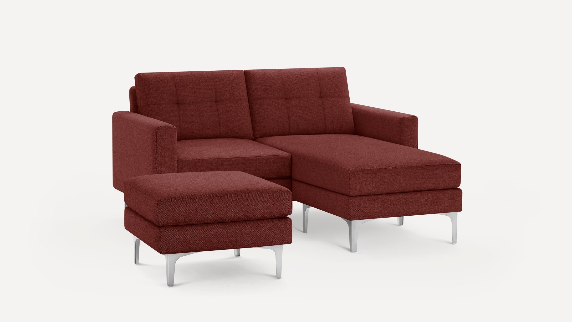 Modern rust-colored fabric sectional sofa with matching ottoman, featuring clean lines, tufted cushions, and sleek silver metal legs.