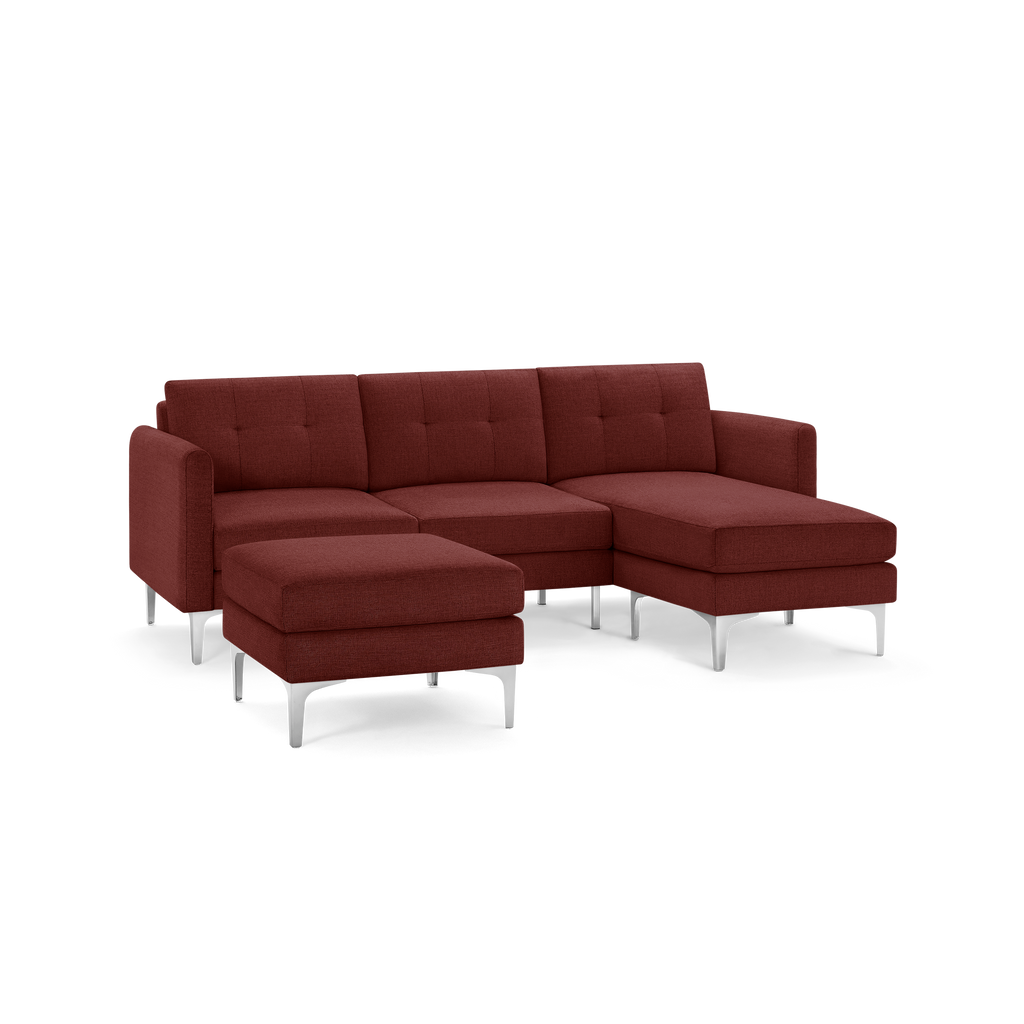 Modern sectional sofa in deep red fabric with tufted cushions, metal legs, and an attached chaise lounge on the right side.