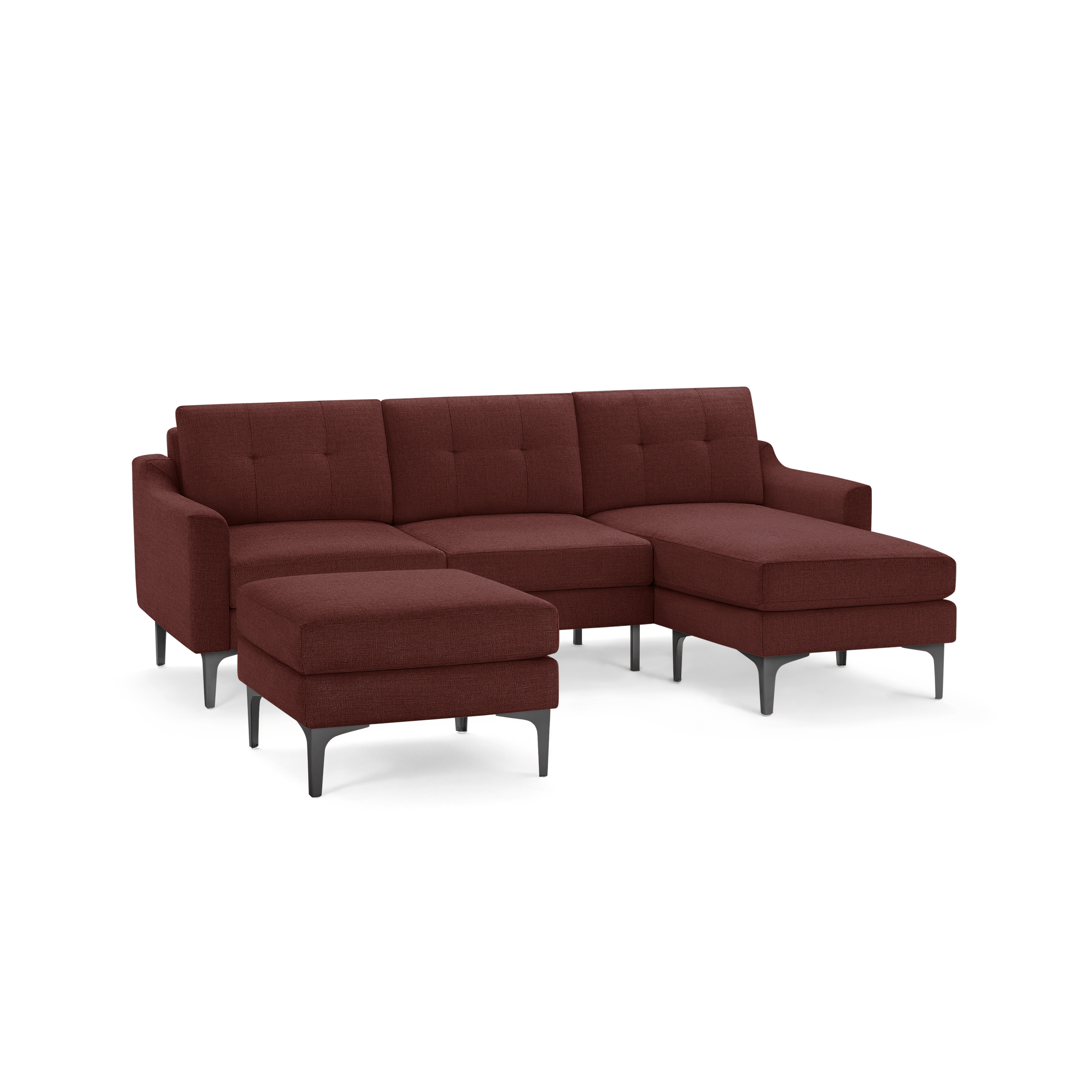 Modern sectional sofa in reddish-brown fabric with tufted cushions, chaise lounge, matching ottoman, and sleek black legs.