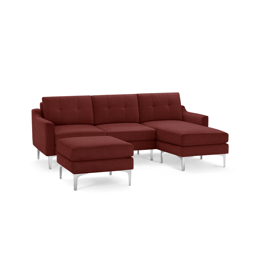 Modern sectional sofa in deep reddish-brown fabric with tufted cushions, metal legs, and a matching ottoman.