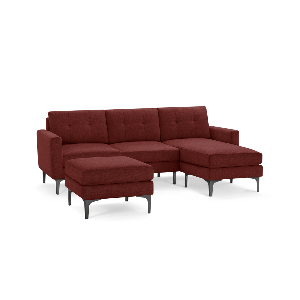 Modern sectional sofa in deep red fabric with tufted back cushions, metal legs, and matching ottoman.