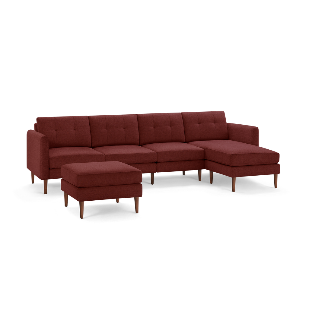 Modern sectional sofa in deep red fabric with button-tufted cushions, wooden legs, and matching ottoman.