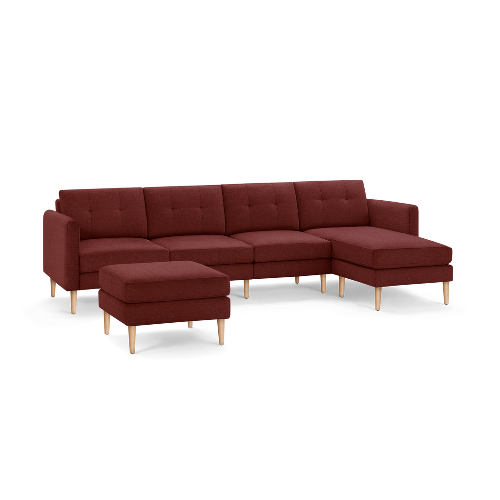 Modern sectional sofa with chaise and matching ottoman, upholstered in deep red fabric with wooden legs.